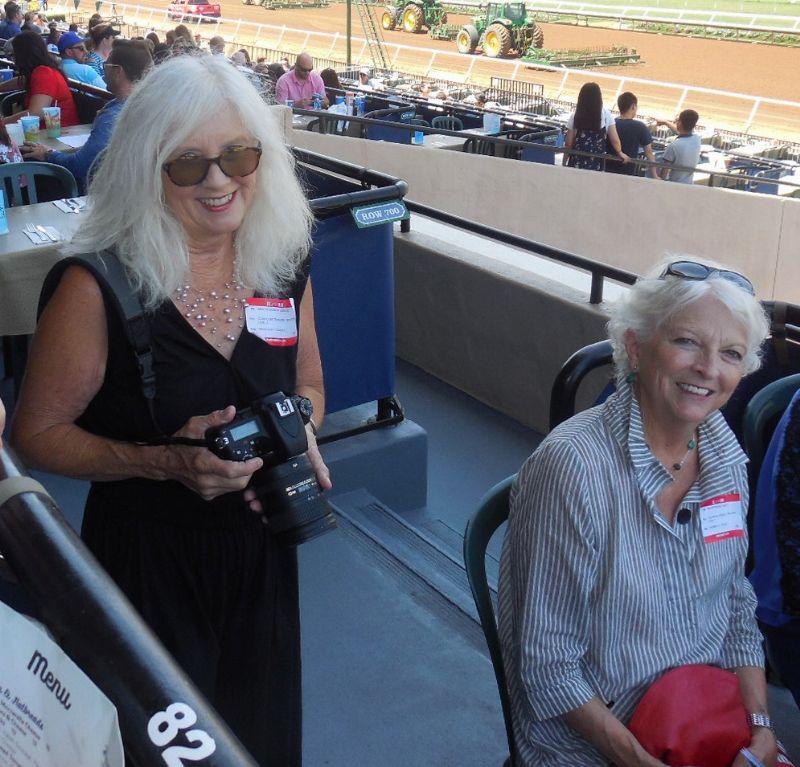 guest in black dress holding a camera and another guest sitting at a table